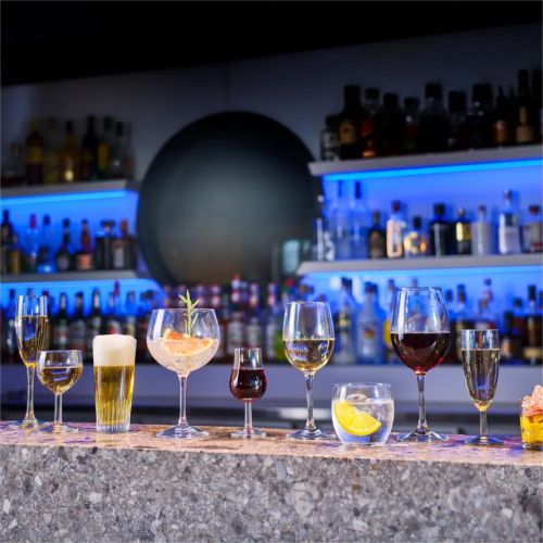 Gevulde Cosy Moments glas 34 cl. met bedrukt logo in een sfeervolle setting op bar geplaatst.