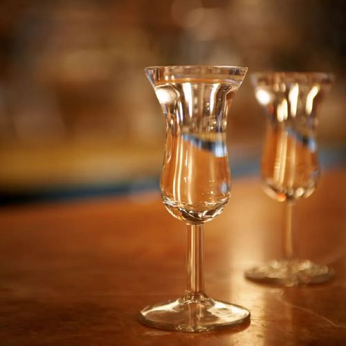 Gevuld Intermezzo borrelglaasje 5 cl met lange steel geplaatst in sfeervolle setting.