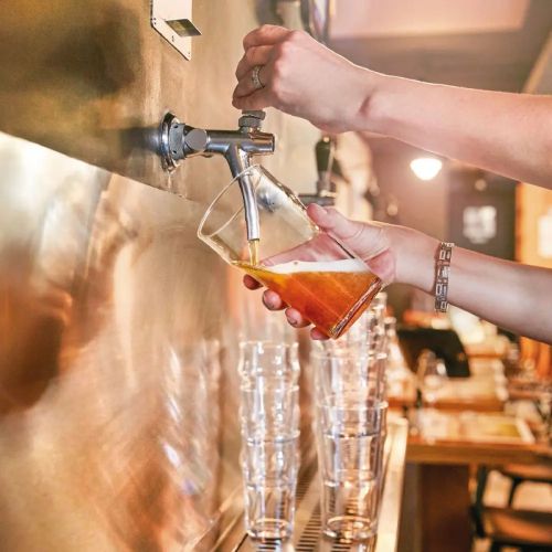 Arcoroc Nonic glas van 28 cl in gebruikssituatie, met drank gevuld en vastgehouden in een hand.