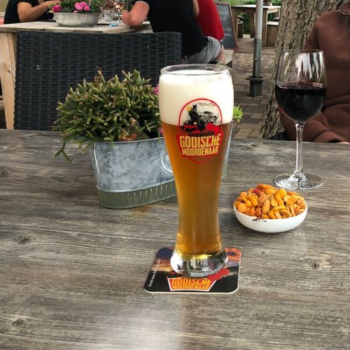 Gevuld Pantheon bierglas 30 cl. TAPMAAT met bedrukt logo in een sfeervolle setting op tafel.