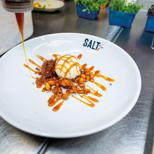 Sfeerbeeld van wit Hotel coupebord 28 cm met vulling en bedrukt logo in een realistische setting.