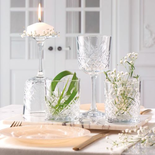 Gevuld Timeless wijnglas geplaatst in sfeervolle omgeving met natuurlijke belichting.