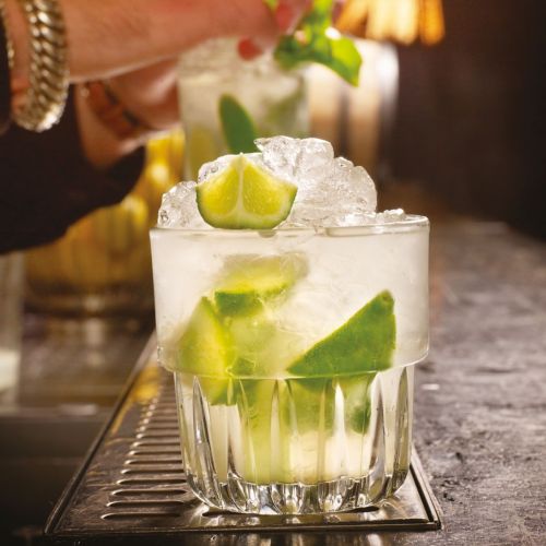 Gevuld Tumbler Onis 23 cl glas geplaatst in een sfeervolle setting.