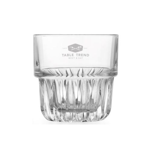 Gravure van TableTrend op het Tumblerglas Onis Everest 26,5 cl, zichtbaar op transparante wand.