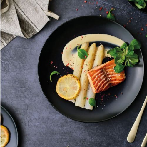 Porseleinen Venus bord 26 cm met logo en vulling, sfeervol gepresenteerd in eetsituatie.